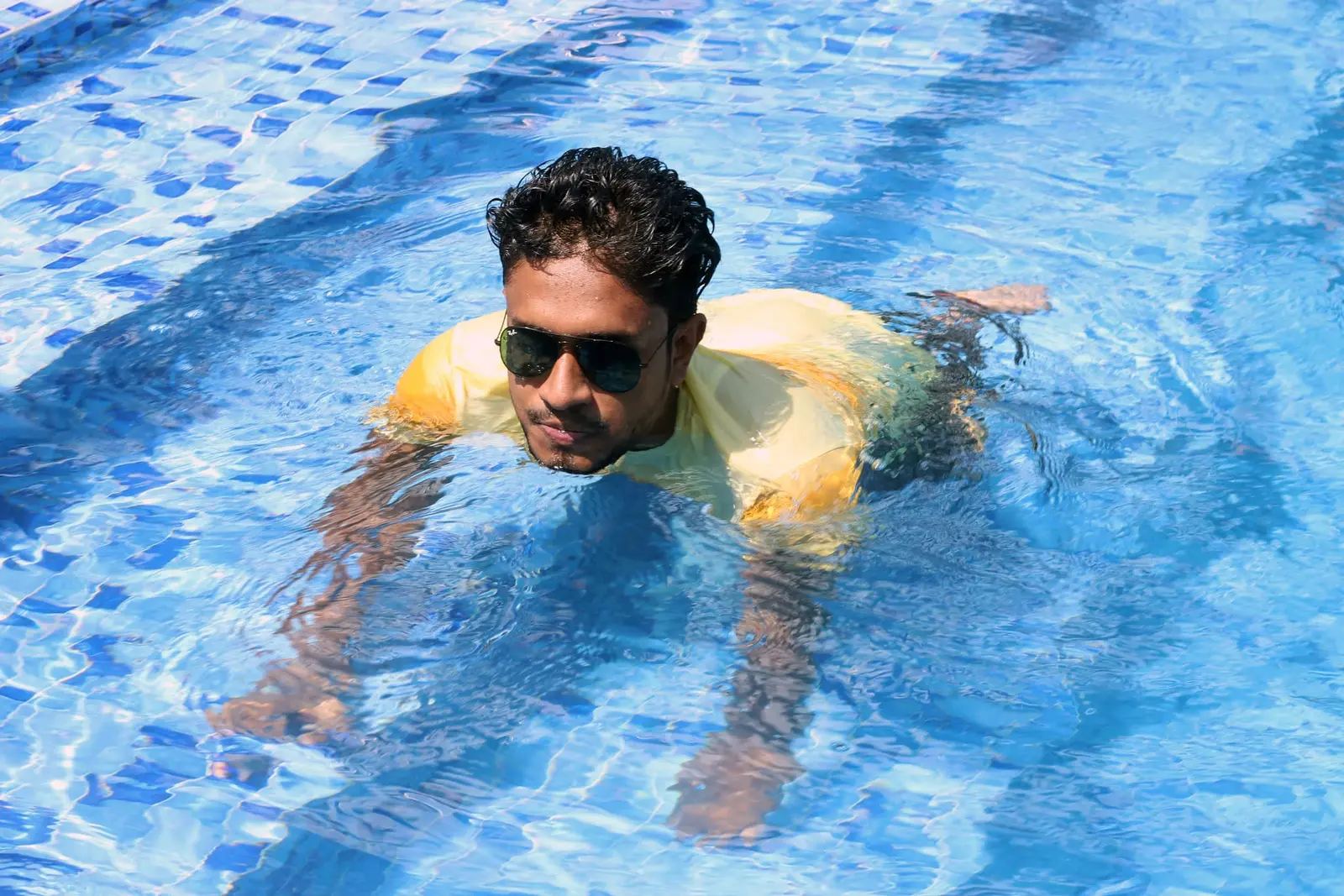 Anik Mahmud swimming independently in a pool.